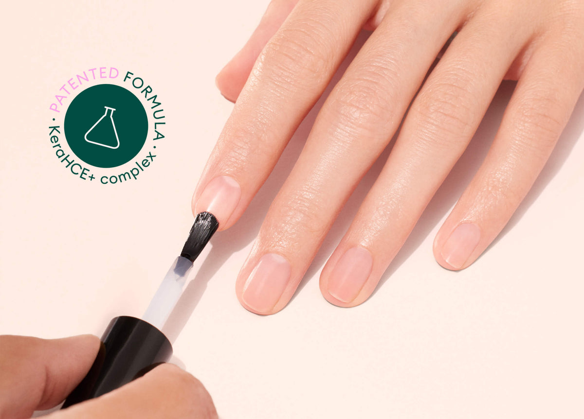A hand is having clear nail polish applied to its fingernails. Next to the hand is a circular logo that reads PATENTED FORMULA, KeraTICE+ complex with a chemical flask icon in the center.