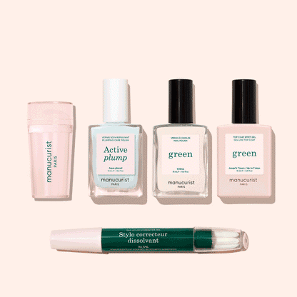 Five manicure products from Manucurist’s French Active™ Kit are shown on a beige background: a pink cylindrical container, a square bottle labeled Active blur, two green-labeled nail polish bottles, and a dual-ended Stylo correcteur pen.