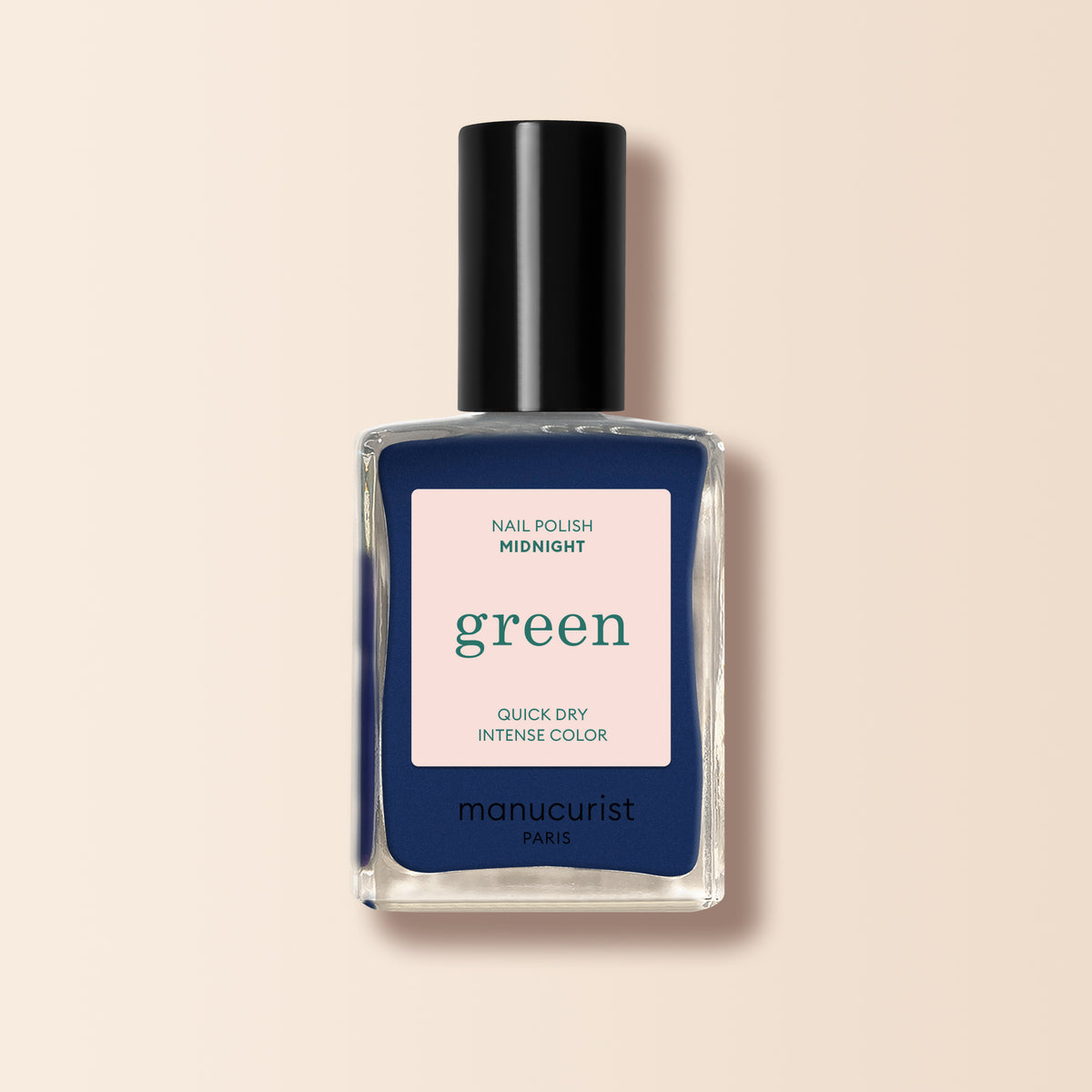 Un flacon transparent de vernis à ongles Manucurist dans la teinte Midnight, affichant QUICK DRY INTENSE COLOR sur une étiquette beige. Le vernis bleu nuit est visible et surmonté d&