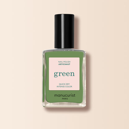 Un flacon de vernis à ongles Artichoke de Manucurist de la gamme Green™, avec un bouchon noir et une étiquette carrée indiquant le nom et la description du produit sur un fond beige clair.