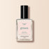 A clear glass bottle of Manucurist Crème nail polish with a black cap and light pink label rests on a beige background.