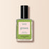 A bottle of Manucurist Green™ nail polish with a black cap, light green liquid, and a label reading Green, Quick Dry Intense Color, Nail Polish Sweet Pea. The background is light beige.