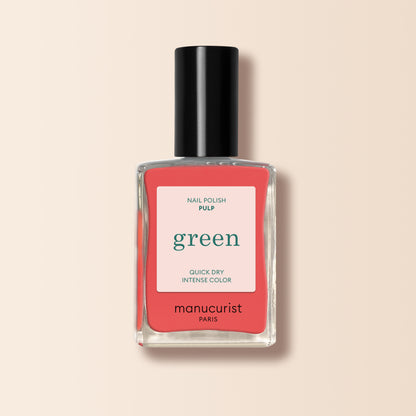 Un flacon de vernis à ongles Pulp de Manucurist avec un bouchon noir et une étiquette rose et blanche indiquant Quick Dry Intense Color. Idéal pour les fans de la teinte Pamplemousse, ce vernis de la gamme Green se distingue sur un fond beige clair.