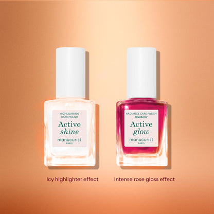 Two bottles of Manucurist’s Active™ Travel-Size Duo are displayed on a peach-toned background: the left features the white “Active Shine” and the right showcases pink “Active Glow.” Captions read “Icy highlighter effect” and “Intense rose gloss effect.” This set is perfect as a holiday gift or an addition to your nail care routine.