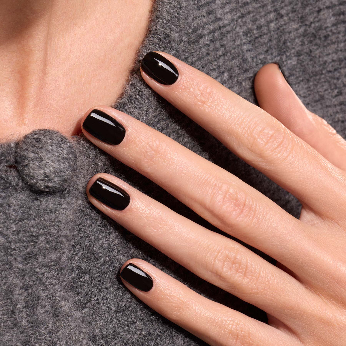 A hand with neatly manicured nails painted in Manucurist&