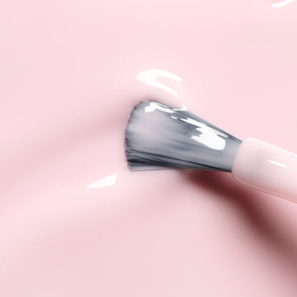 A close-up of a makeup brush applying Manucurist&