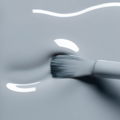 A close-up of a brush spreading thick, glossy Mist Grey gel from Manucurist, creating smooth streaks with reflective highlights on the surface.
