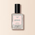 A bottle of Manucurist Moon nail polish features a pearly white, clear liquid with shimmer, black cap, and light pink label from the Green™ range, displayed on a beige background.