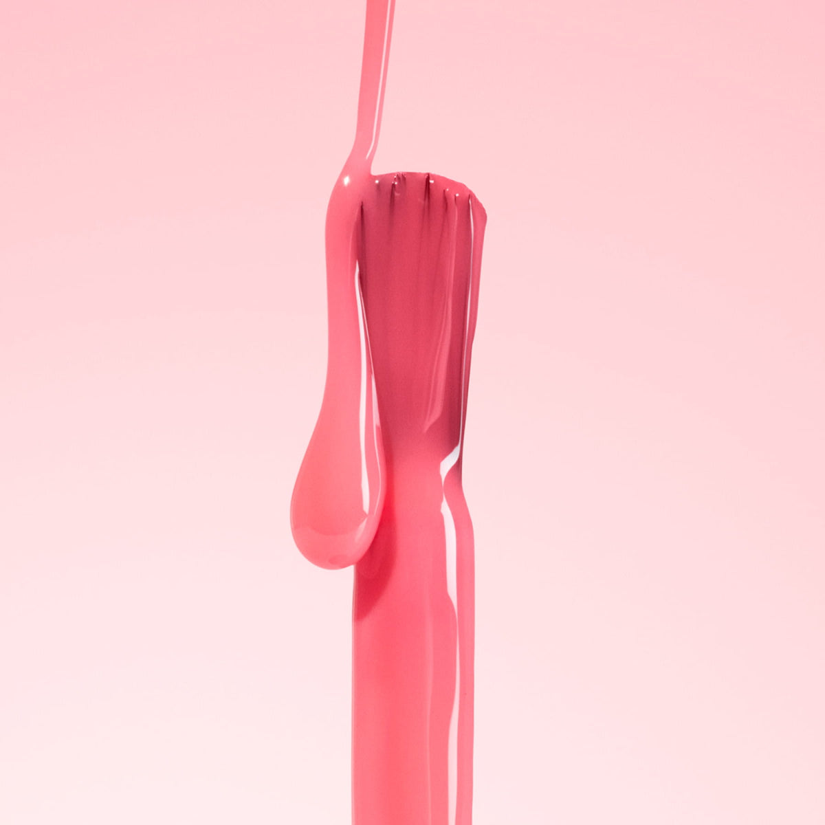 A fork covered in glossy, pink liquid stands upright against a soft pink background.