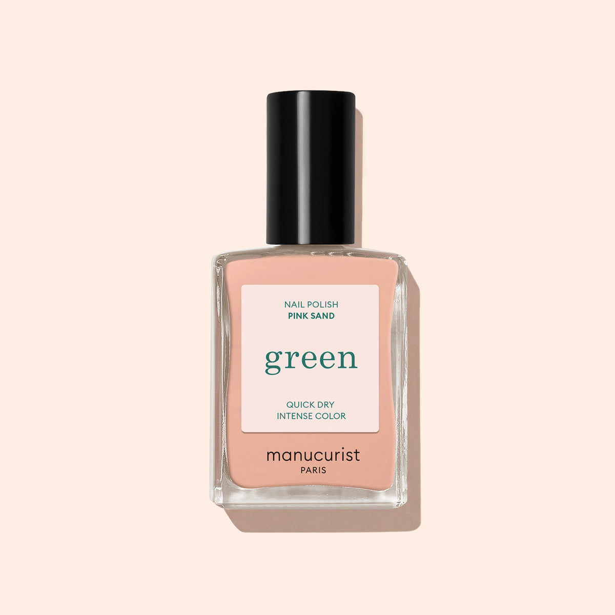 Manucurist Pink Sand nail polish features a light pink shade with orange undertones and a black cap, displayed against a pale beige background. Part of the eco-friendly Green collection by Manucurist.