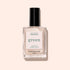 A bottle of Manucurist Pearlescent polish, a pearlescent beige shade with pink undertones, labeled green, sits in a clear rectangular glass bottle with a black cap against a light beige background.