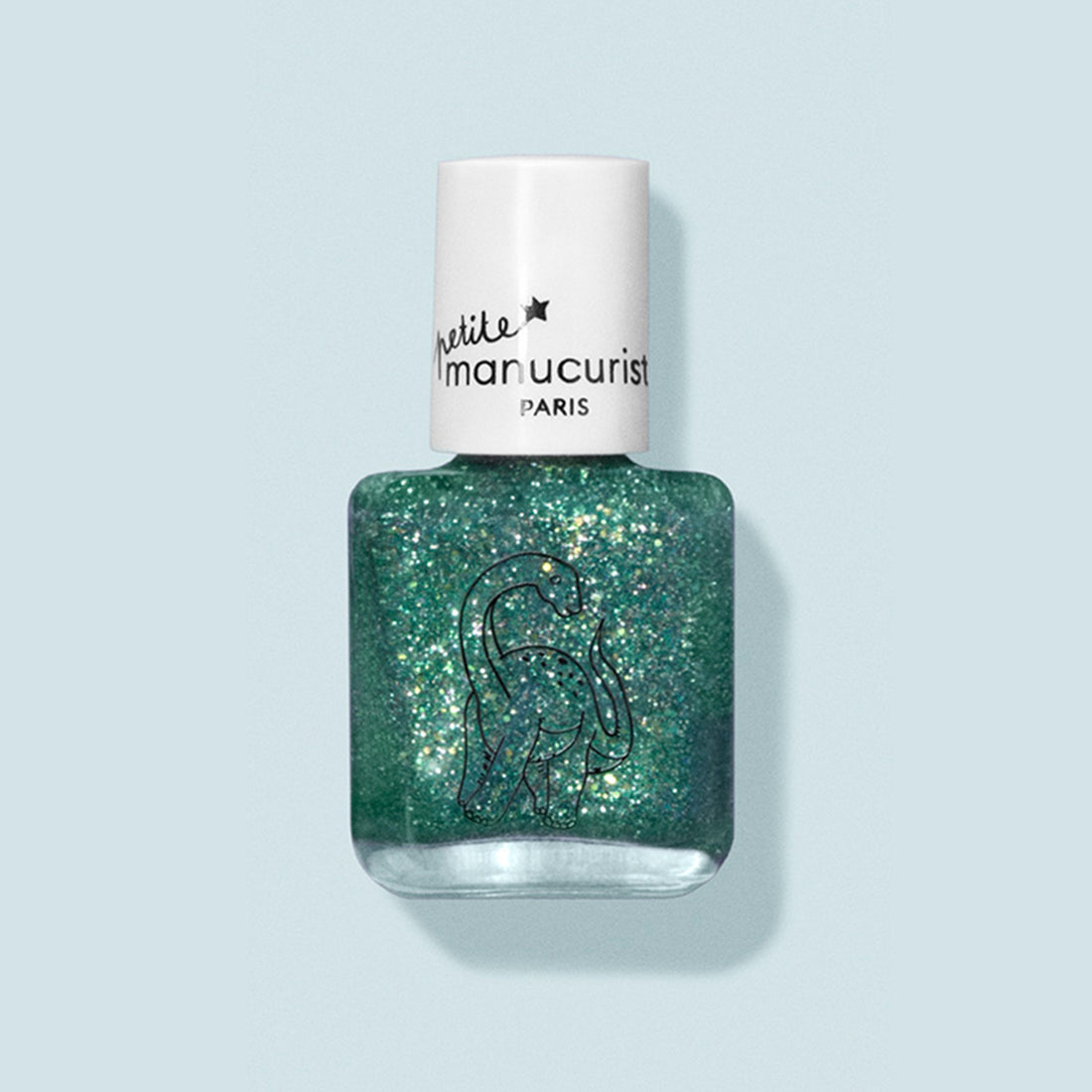 Un flacon de vernis à ongles pour enfants Marius le Diplodocus by Manucurist, aux ingrédients naturels, avec un capuchon blanc portant la mention petite manucurist PARIS et un dessin au trait de dinosaure sur le flacon, sur fond bleu pâle.