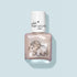A bottle of water-based, pearlescent pink kids nail polish called “Pénélope the Triceratops” by Manucurist, with a white cap and cute triceratops design on the front, shown against a light blue background.
