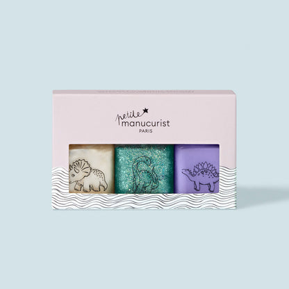Le coffret de vernis à ongles pour enfants Wild Life Collection de Manucurist comprend trois teintes lavables — crème, bleu sarcelle pailleté et violet — chacune ornée d’un motif dinosaure, le tout dans une boîte rose Petite Manucurist Paris. Formule douce ; parfaite pour les enfants.