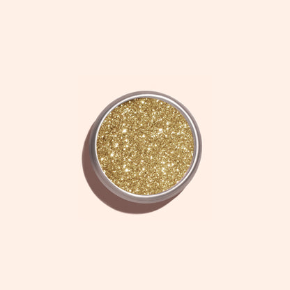 A round Manucurist Golden Chrome Powder container, viewed from above on a pale beige background, ideal for achieving a dazzling chrome finish.
