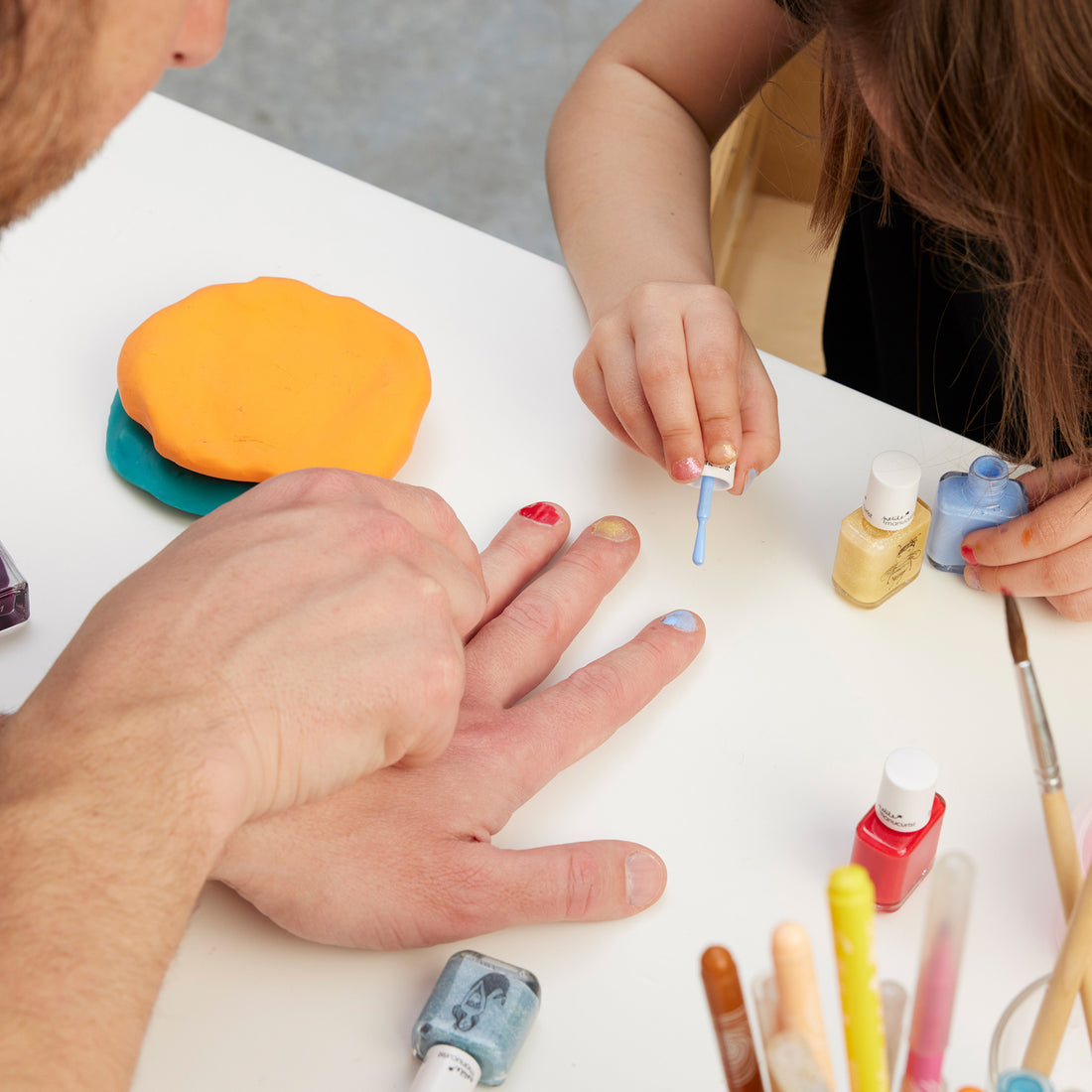 Un enfant utilise le coffret Green Flash™ You  Me at a Tea Party de Manucurist pour peindre les ongles d&