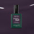 Un flacon de vernis à ongles Manucurist Queen of Night vert foncé repose sur un fond violet brillant, mettant en valeur ses sous-tons gris et son style unique.