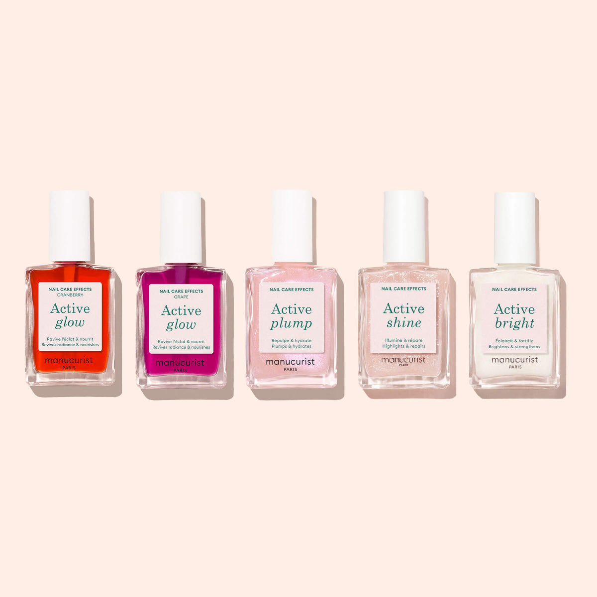 Five bottles of Manucurist nail care polish are displayed on a pale background, each showcasing a unique effect: Active Glow Cranberry, Active Plump, Active Shine, and Active Bright. This plant-based collection by Manucurist features options ranging from the tinted luminosity of Active™ Glow Cranberry to soft coral gloss shades, offering healthy and radiant nails with every application.