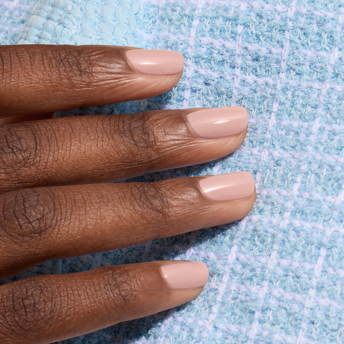 A hand with short, neatly manicured nails painted in Manucurist&