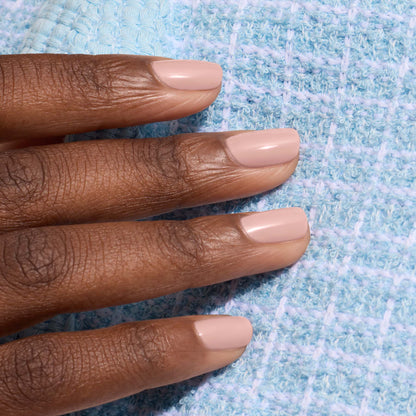 A hand with short, neatly manicured nails painted in Manucurist&