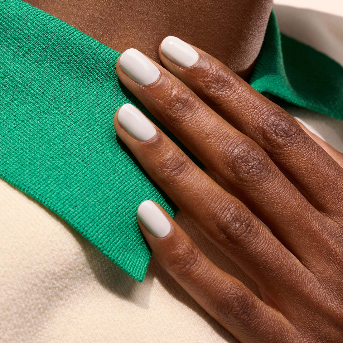 A hand with neatly manicured, short nails coated in Manucurist&