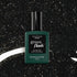 Un flacon de vernis semi-permanent Manucurist Sparks posé à la verticale sur un fond noir parsemé de mouchetures blanches semblables à des étoiles.
