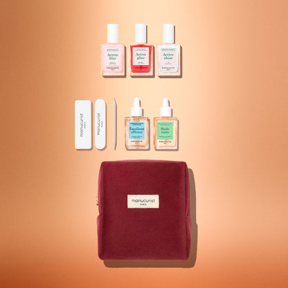 The Manucurist Active™ Starter Kit Gift Set features everything you need to elevate your manicure routine: three nail polishes, two cuticle oils, two nail files, and a wooden cuticle stick, all beautifully packaged in a burgundy velvet pouch and arranged on a soft peach background.