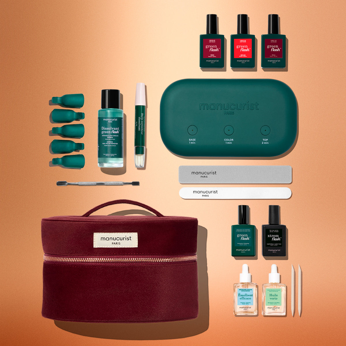 The Manucurist Green Flash™ Starter Kit Gift Set features gel polish manicure nail polishes, remover, files, a green LED lamp, cuticle tools, remover pads, and a stylish burgundy case—all neatly arranged on an orange background—providing everything you need for long-lasting nails and a professional salon-style manicure at home.