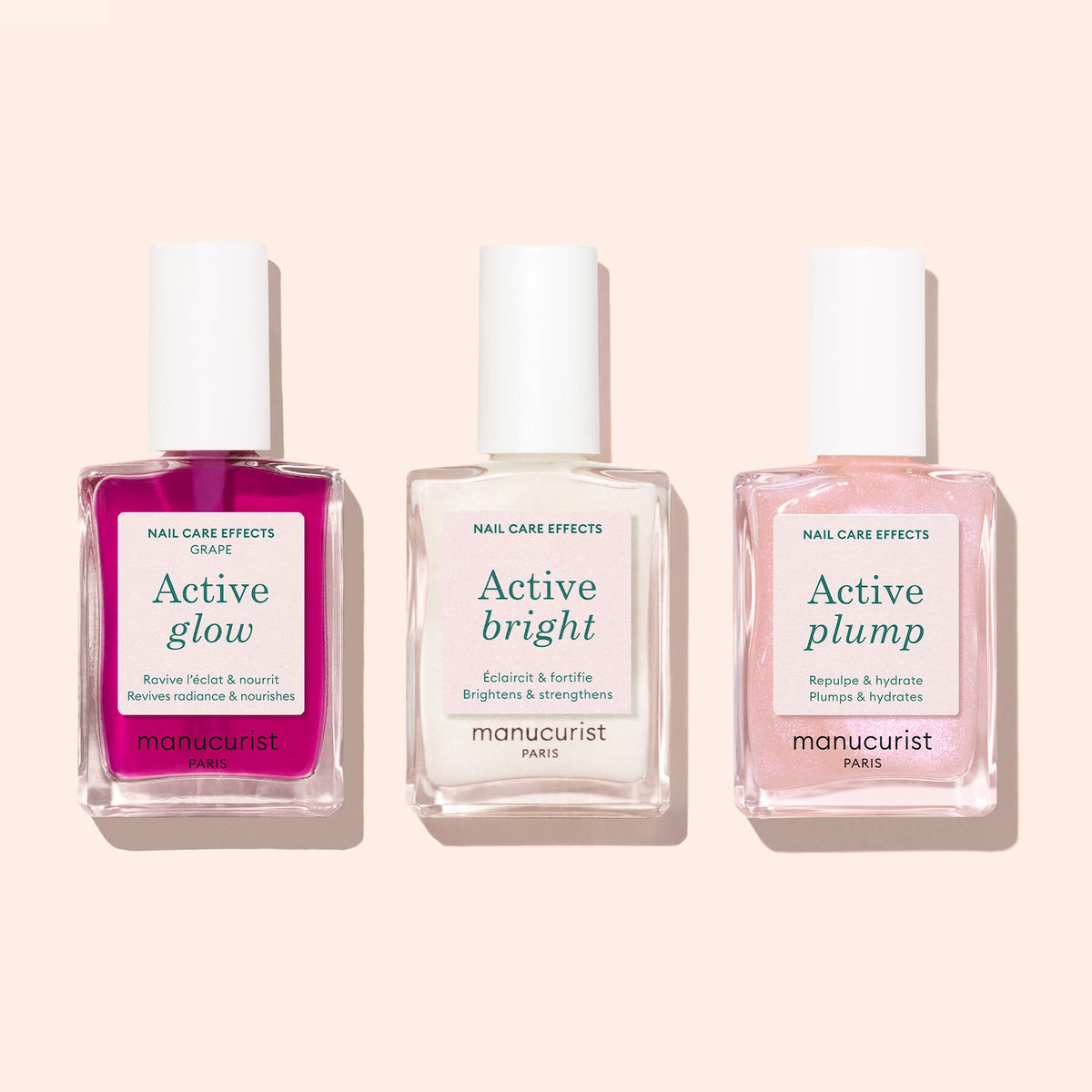 Trois flacons de vernis à ongles étiquetés Active™ Glow Grape, Active™ Bright et Active™ Plump de Manucurist sont disposés en ligne sur un fond pêche clair. Idéal pour les adeptes du soin des ongles, chaque flacon dévoile une nuance unique — rose, blanc et rose pâle — pour apporter un éclat naturel et radieux à votre manucure.