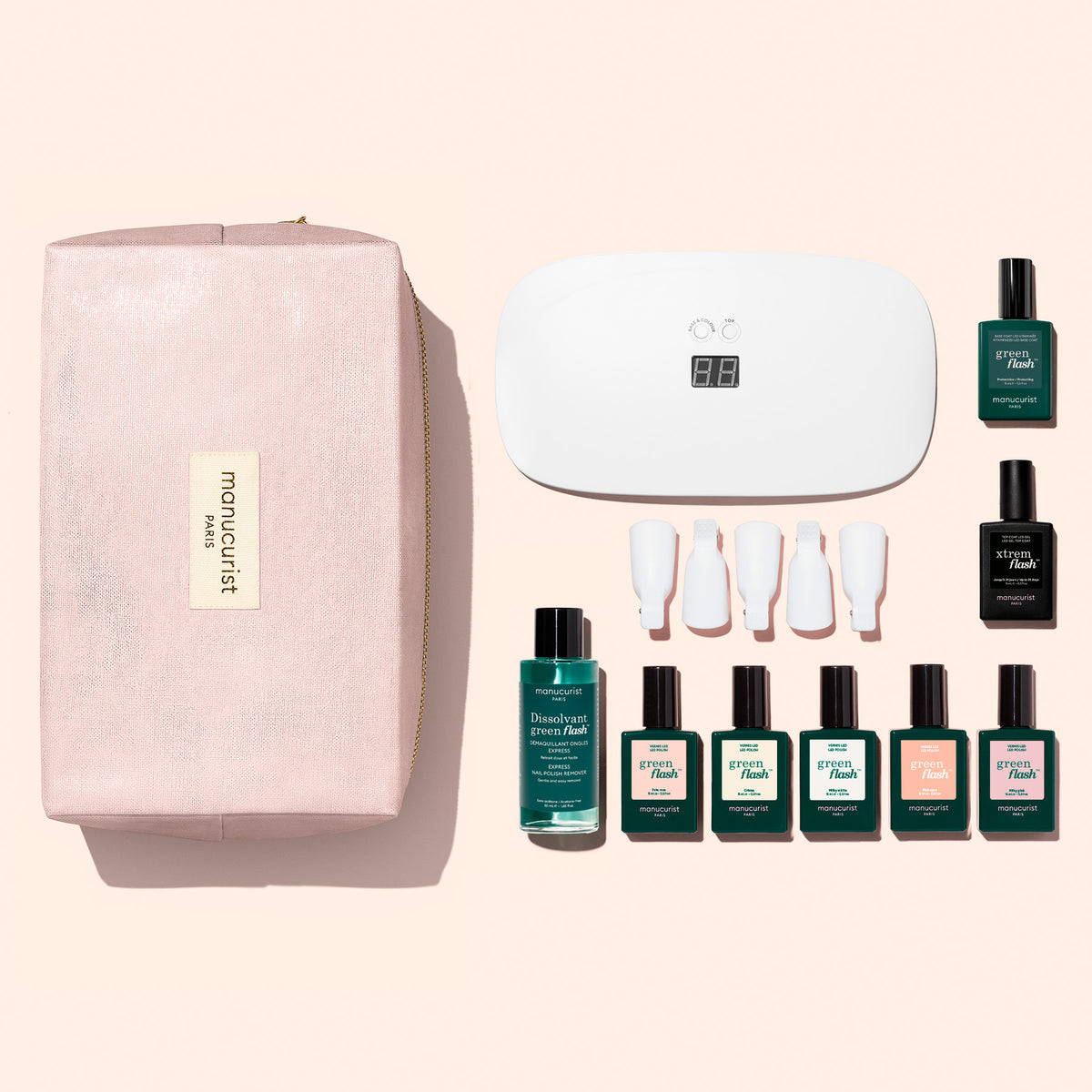 Un Super Starter Kit Manucurist de vernis semi-permanent LED Soap Nails dans une trousse de maquillage rose, comprenant une lampe LED, du dissolvant, cinq vernis semi-permanents, une Base Coat, un Top Coat et cinq pinces en plastique pour les doigts, pour une manucure ultra-brillante.