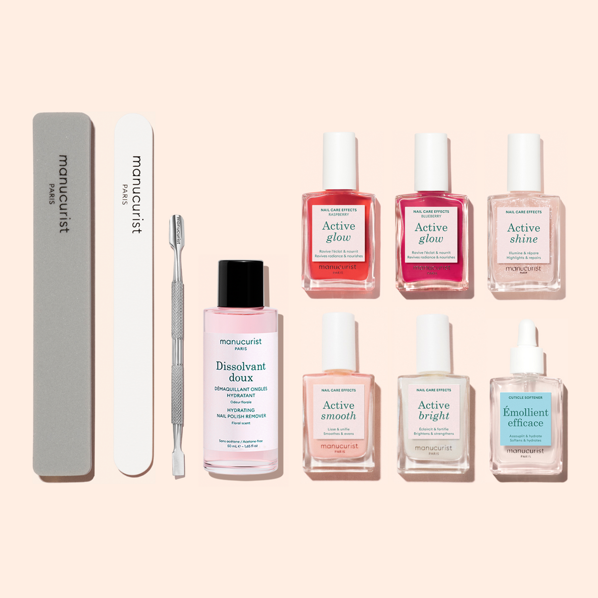 The Super Active Manicure Kit by Manucurist features seven nail treatment bottles, a glass file, a buffer, a metal cuticle pusher, and a pink nail polish remover bottle—all beautifully arranged on a light beige background—making it the ideal choice for elevating your nail care routine and ensuring a flawless manicure every time.