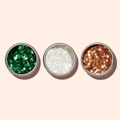 Trois pots métalliques ronds de Paillettes Biodégradables Copper Manucurist sont disposés côte à côte sur un fond beige clair. Les paillettes vertes, blanches et dorées sont parfaites pour le Nail Art.