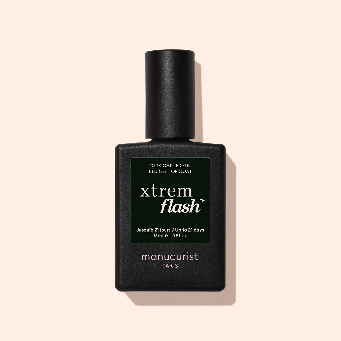 A black bottle of Manucurist Xtrem Flash™ Gel Top Coat stands against a pale pink background, featuring a dark green label with white and yellow text highlighting express removal and flawless wear.