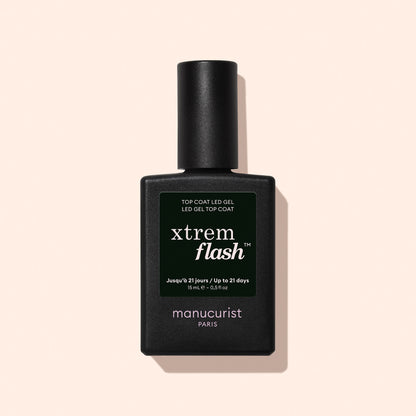 A black bottle of Manucurist Xtrem Flash™ Gel Top Coat stands against a pale pink background, featuring a dark green label with white and yellow text highlighting express removal and flawless wear.