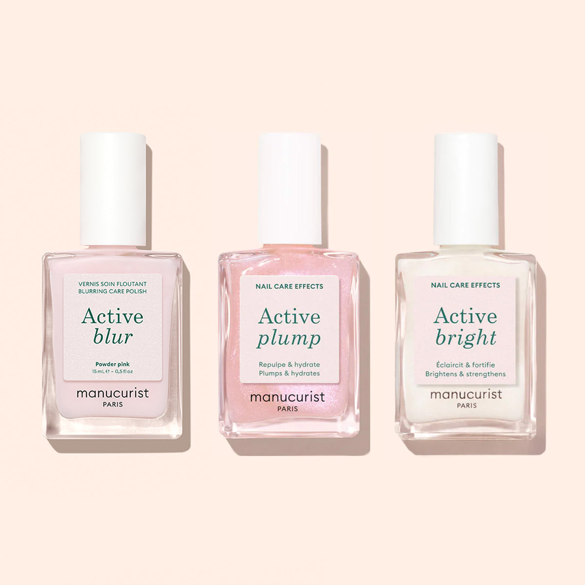 Trois flacons de vernis soin pour ongles Manucurist — Active™ Blur, Active Plump et Active Bright — sont présentés sur un fond rose clair. Ces formules innovantes mettent en avant le vernis Manucurist Active™ Blur pour un fini mat impeccable, ainsi qu&