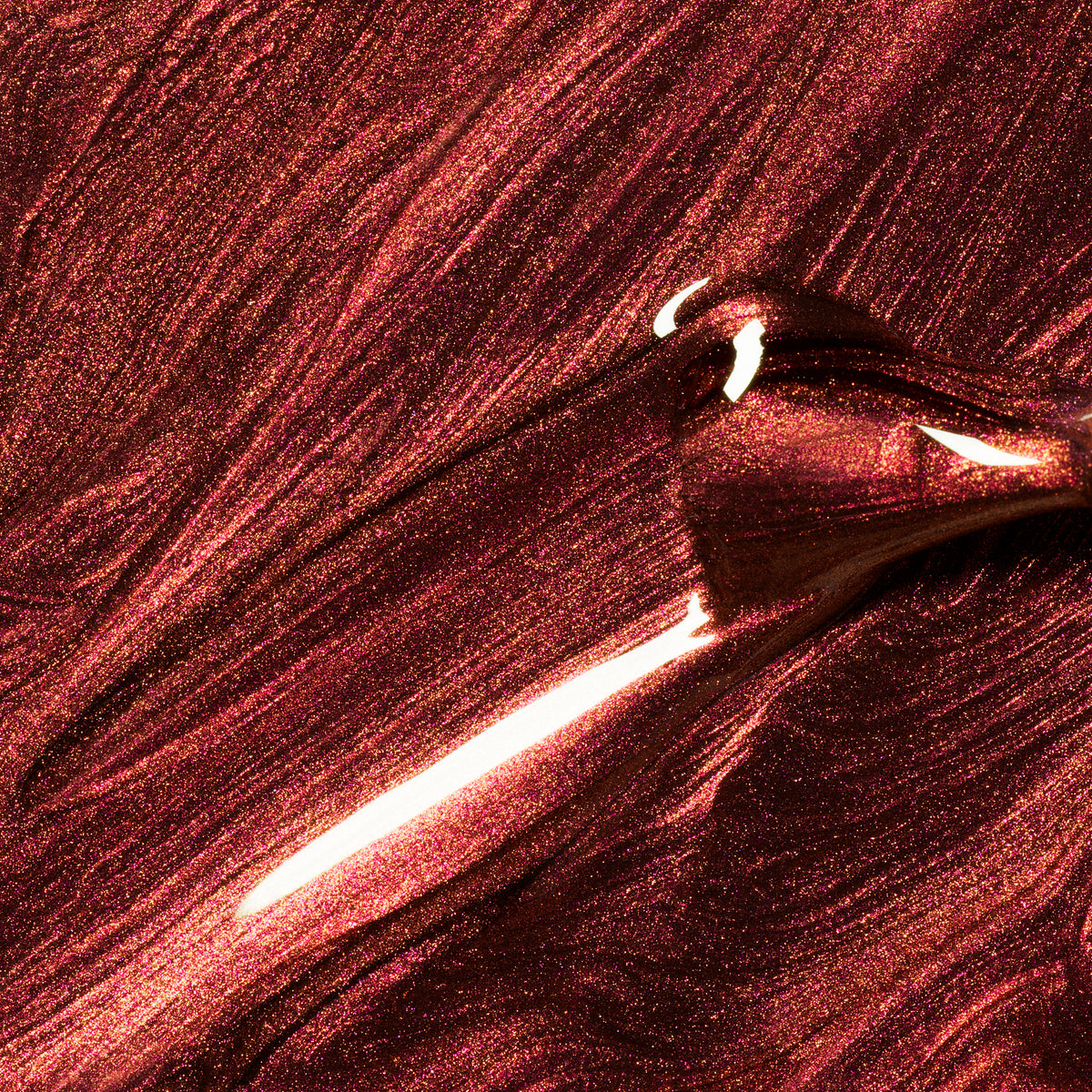 Gros plan sur Utopia de Manucurist, un vernis gel bordeaux métallique scintillant, appliqué au pinceau pour créer des vagues lisses et réfléchissantes — parfait pour les adeptes des finis brillants et métalliques.