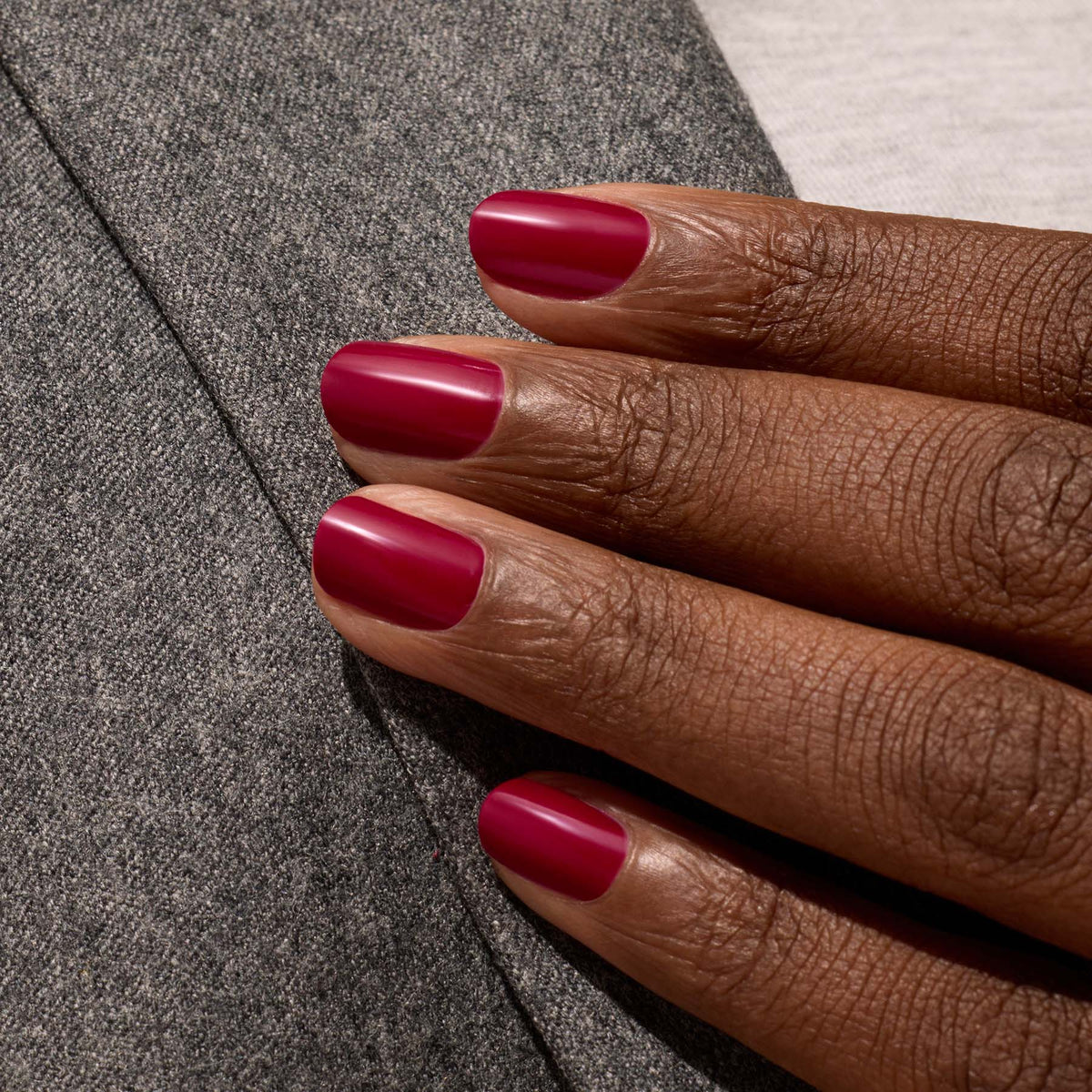 A close-up of a hand with short, neatly manicured nails painted in Manucurist&