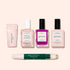 Five manicure products from the Manucurist French Color Kit are shown on a light beige background: a nail buffer, two nude polishes, one bright pink polish, a top coat, and a green corrector pen.