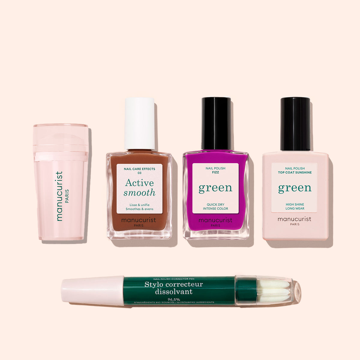 Five items from the Manucurist French Color Kit are arranged on a light background: a pink buffer, brown Active Smooth polish, purple polish, light pink top coat, and a dual-ended green nail polish corrector pen.
