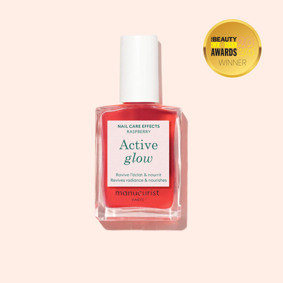 A bottle of Manucurist Active Glow nail care polish in raspberry, with a white cap, is shown on a light pink background. A gold Beauty Global Awards Winner badge appears in the top right corner.
