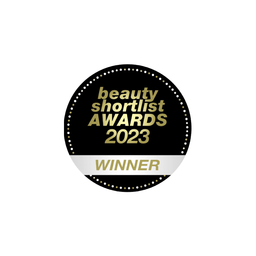 Un badge circulaire noir et or avec une bordure pointillée indiquant beauty shortlist AWARDS 2023 WINNER en lettres or et blanches en gras.