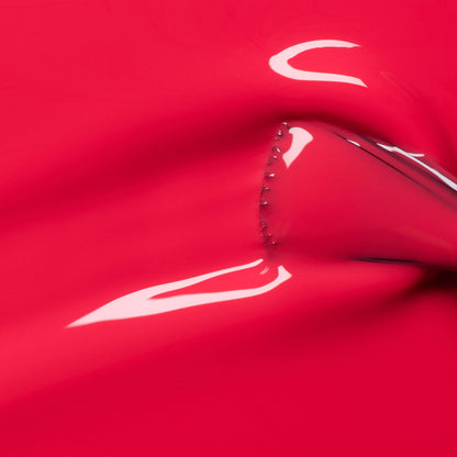 A shiny, stretchy pink-red surface—reminiscent of Manucurist&
