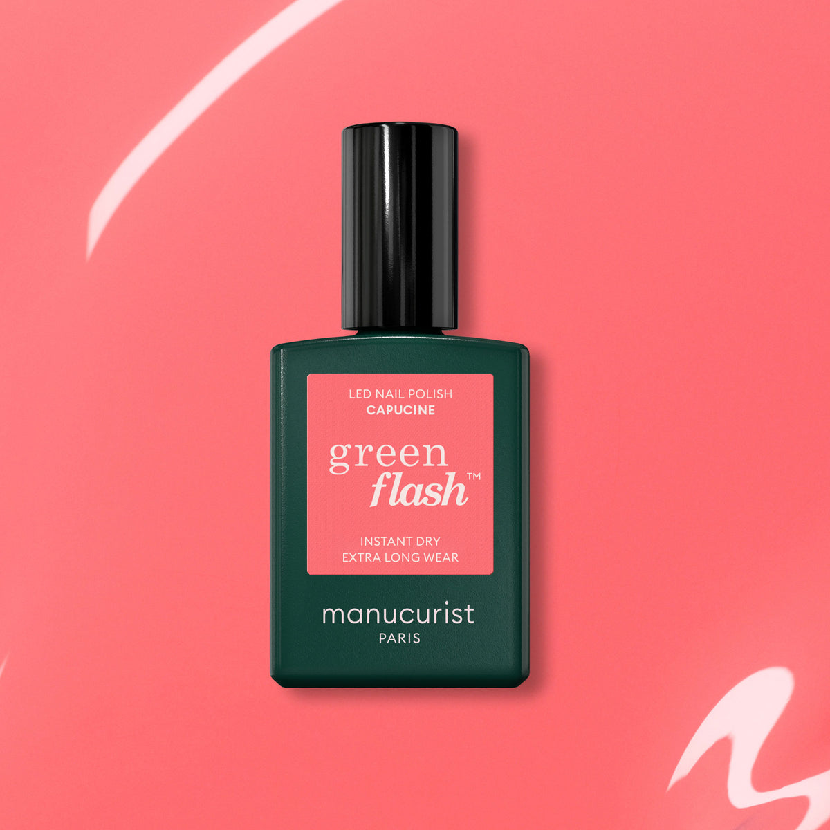 A dark green bottle of Manucurist Capucine Green Flash gel polish is displayed against a coral pink background with white curved accents.