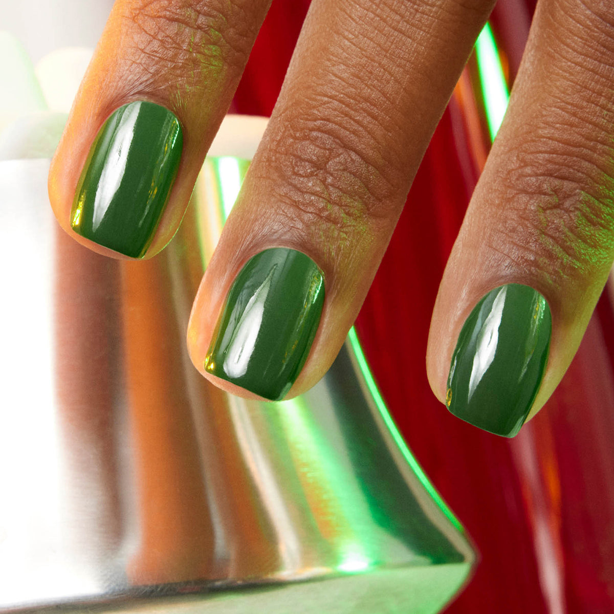Gros plan sur trois doigts aux ongles impeccablement manucurés, vernis avec Jade de Manucurist, un vert minéral brillant, près d&