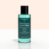 A green bottle of + Green Flash™ Gel Polish Remover by Manucurist-test, gentle and acetone-free with 99.4% bio-sourced ingredients, stands on a pale surface against a light background.