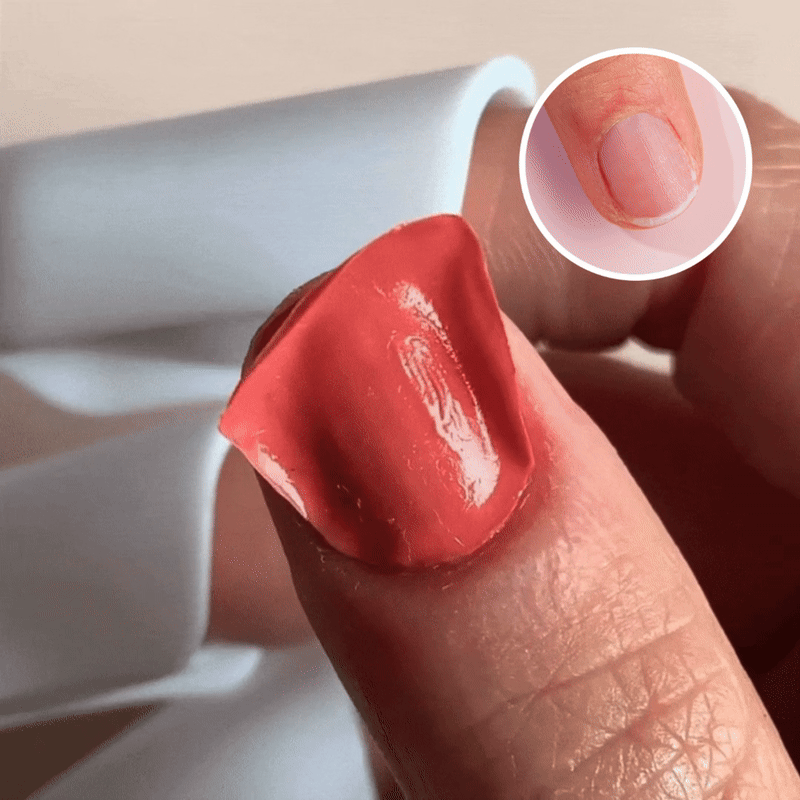 A thumb with a fake red nail tip being held above a real, short natural nail; a small inset image in the corner shows a close-up of the same thumb with only the natural nail visible.