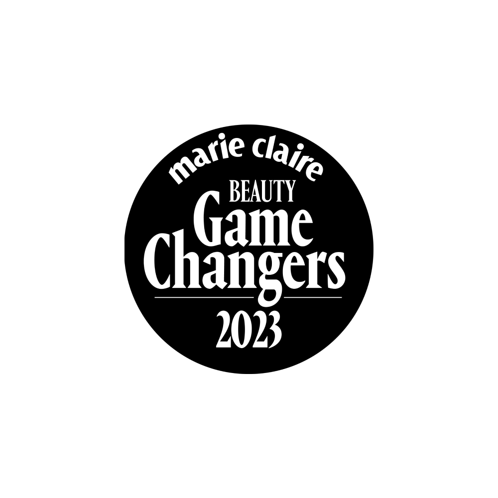 A circular black logo with white text that reads: marie claire BEAUTY Game Changers 2023.