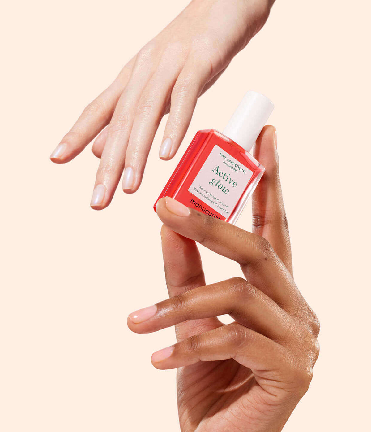 A hand holds a bottle of red Active Glow nail serum, while another hand with manicured nails is shown above against a beige background.