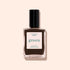 A bottle of Manucurist Mocha, a dark brown nail polish with cool undertones and a black cap labeled “green,” is shown against a pale beige background.