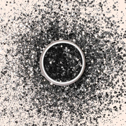 Une bague en argent posée sur une surface claire, entourée d&